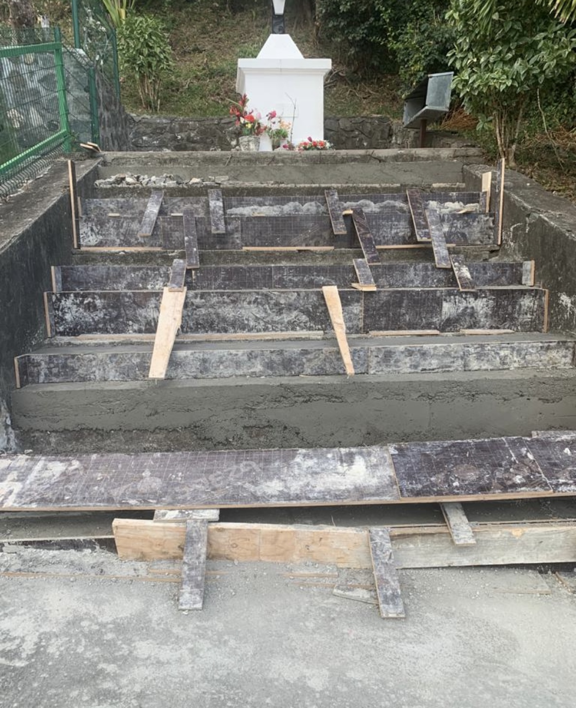 Marches d'escalier en cours de carrelage, coffrages bois et chape fraîche